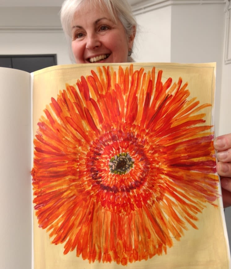 picture of a woman holding a painting of an orange flower