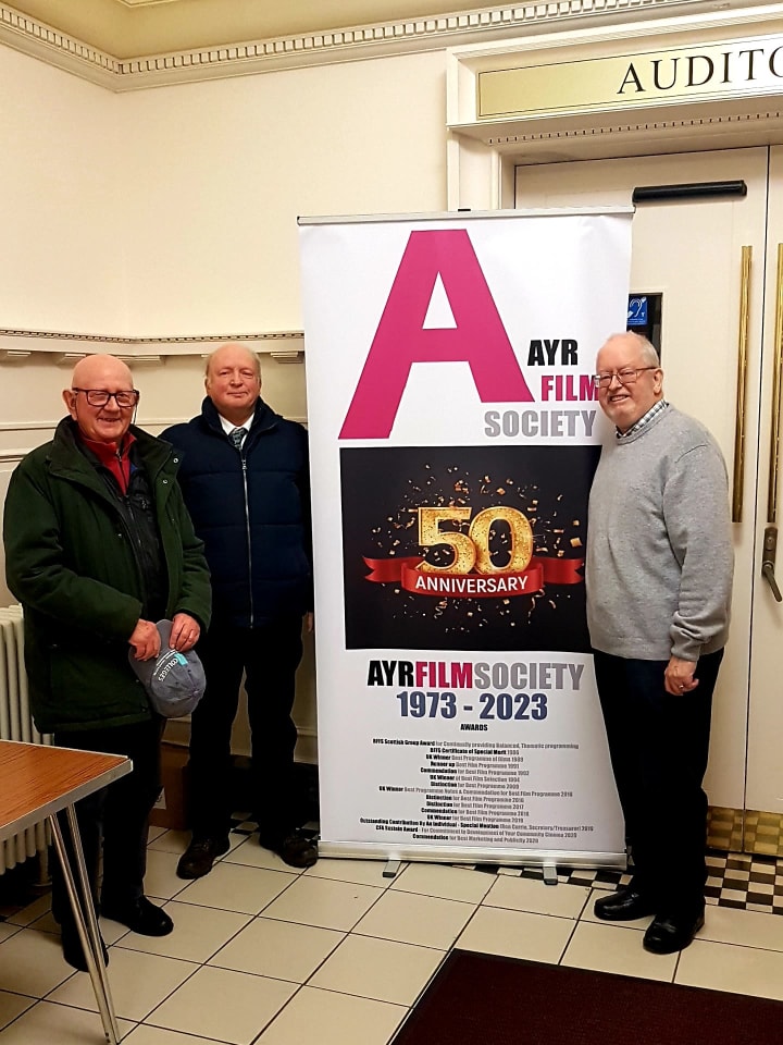 Three man standing by a roller banner