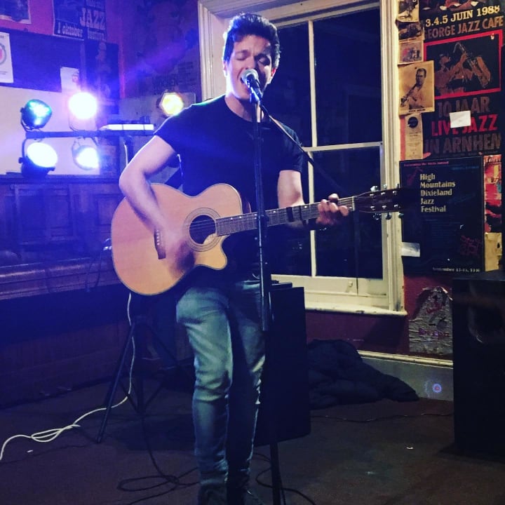 Picture of a man playing guitar inside a pub