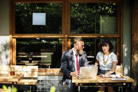 man and woman holding a business meeting outside