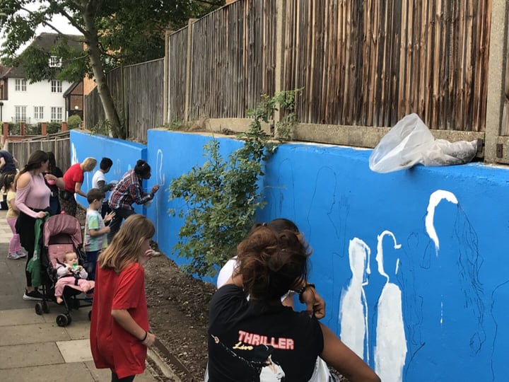 Picture of young people doing mural painting outdoors
